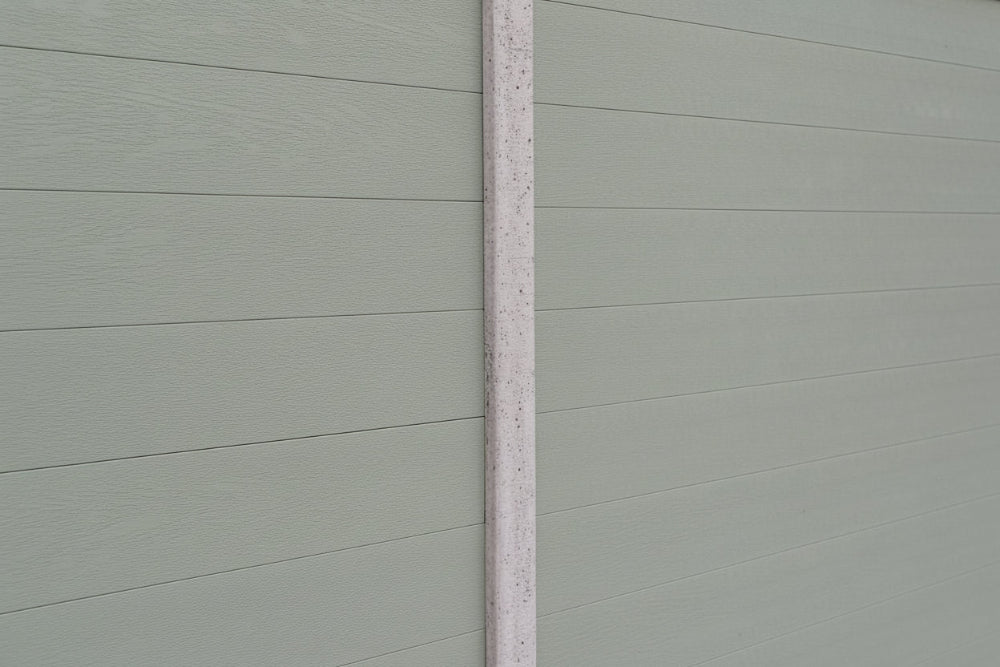 Close-up of a olive grey paneled fence panel in concrete post